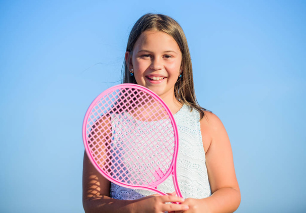 Sporty kid. Small girl with pink tennis racket. Summer leisure. Sport game. Playful cheerful kid. Happy childhood. Positive. Emotional baby. Active life. Child play tennis blue sky background - Photo, image