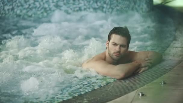 Bonito homem descansando no spa jacuzzi. Sexy homem relaxante na banheira de hidromassagem - Filmagem, Vídeo