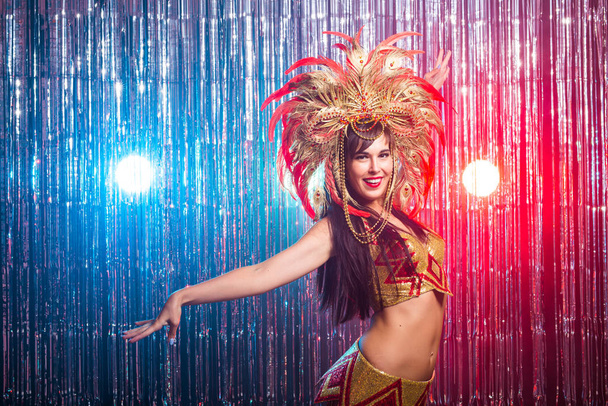 Καρναβάλι, χορός της κοιλιάς και την ιδέα των διακοπών-όμορφη γυναίκα χορεύτρια Σάμπα φορώντας χρυσό κοστούμι και χαμογελαστή - Φωτογραφία, εικόνα