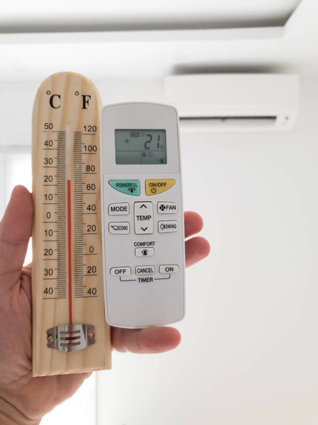 Moderní klimatizační jednotka s rukou drží ovladač a tam - Fotografie, Obrázek