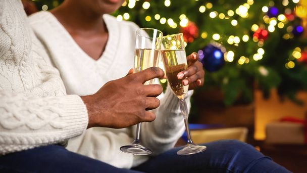 Černý pár cinkající sklenice se šampaňským, slaví Vánoce - Fotografie, Obrázek