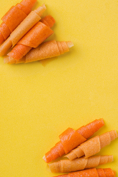rolos de fruto de cor-de-laranja, manga, banana em um contexto amarelo. lugar para texto
 - Foto, Imagem