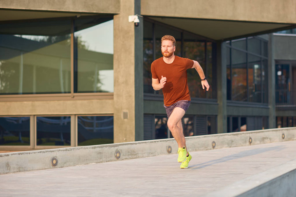 Młody mężczyzna ćwiczący / biegający w parku miejskim. - Zdjęcie, obraz