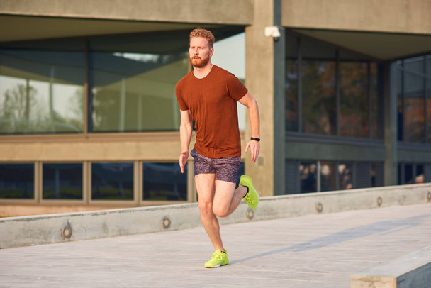 Young man exercising / running in urban park. - 写真・画像