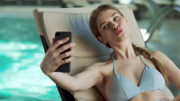 Closeup girl making selfie by pool at spa. Girl in swimwear enjoying vacation - Filmmaterial, Video