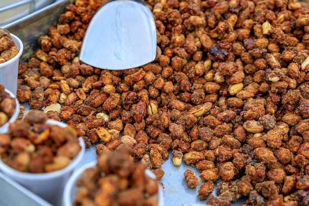 London street food - roasted caramelized peanuts in plastic cups on a cart on a bridge in London, England, UK - Photo, Image