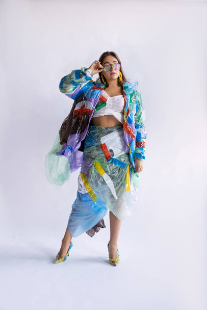 Woman addicted of sales and clothes, wearing plastic, recycling concept - Fotó, kép