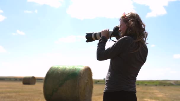 Kobieta fotograf strzela stogi siana - Materiał filmowy, wideo