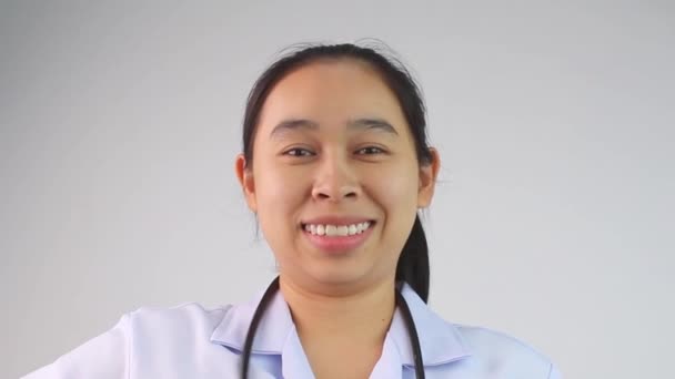 Zelfverzekerde lachende arts die haar stethoscoop vasthoudt om te insinueren dat het tijd is voor een controle van de witte achtergrond. - Video