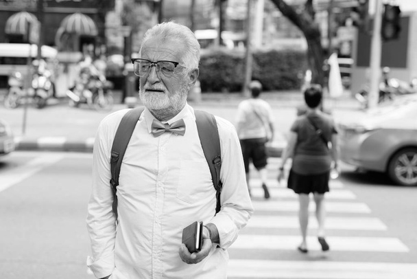 黒と白で街を探索ハンサムな髭の上級観光客の男 - 写真・画像