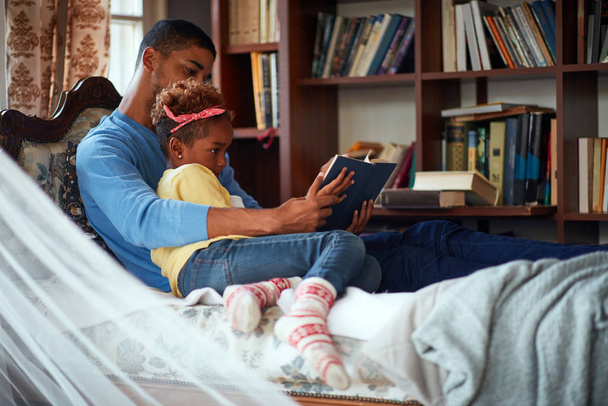 Happy Father and daughter spending Christmas time together, daddy reading fairy tales - Foto, imagen