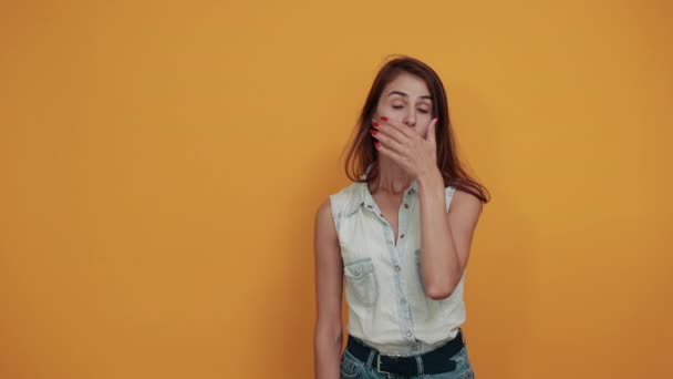 Shocked caucasian young woman keeping hand on mouth, pointing at camera - Filmagem, Vídeo