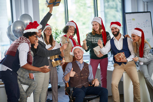 winter holidays at work. Group of young  business people  celebrating Christmas  - Fotografie, Obrázek
