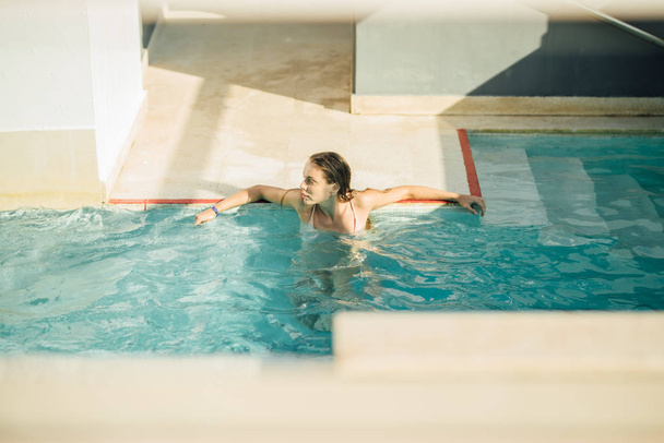 Jovem mulher atraente na piscina relaxante
 - Foto, Imagem