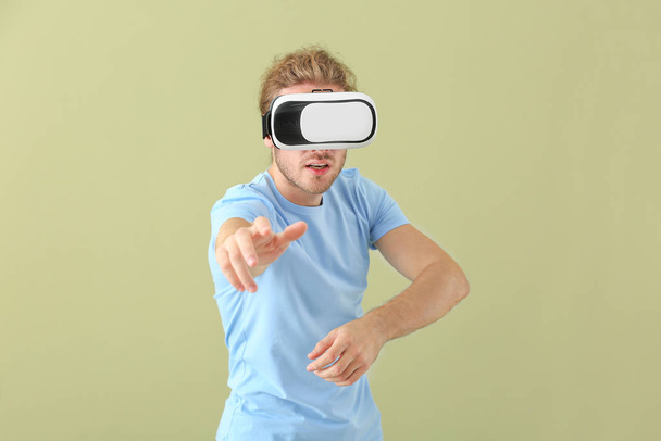 Młody człowiek w okularach VR na kolorowym tle - Zdjęcie, obraz