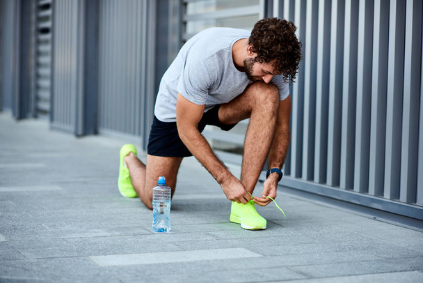 Man tying running shoes on the street. - Photo, Image
