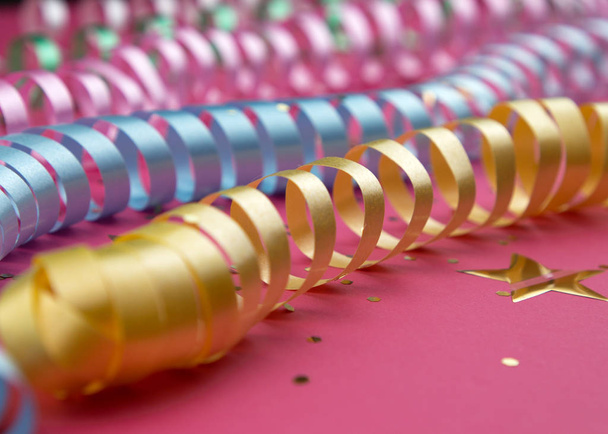 Karnawał świąteczne curling kolorowe papierowe serpentyny dekoracje na różowym tle - Zdjęcie, obraz