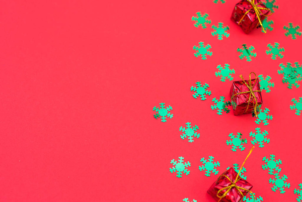 Weihnachtskomposition von Geschenken und Spielzeug auf rotem Hintergrund. Winterhochzeitsdesign. flache Lage, Draufsicht. Freiraum für Text. - Foto, Bild