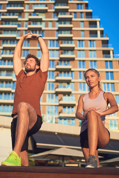 Modern couple doing exercise in urban area. - Photo, Image