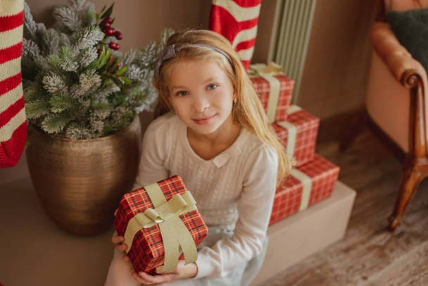Fille regardant cadeau près de l'arbre de Noël
 - Photo, image