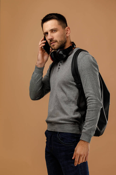 handsome young man with headphones and backpack - Foto, imagen