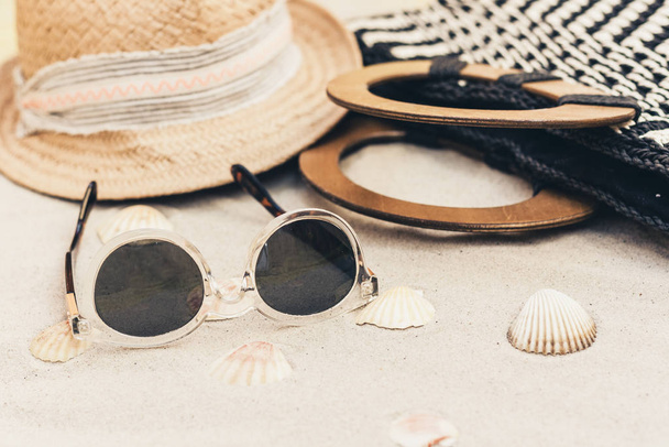 Straw hat, bag and sun glasses on a tropical beach . - Foto, Imagem