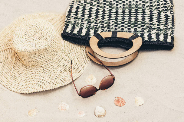 Straw hat, bag and sun glasses on a tropical beach . - Foto, Imagen