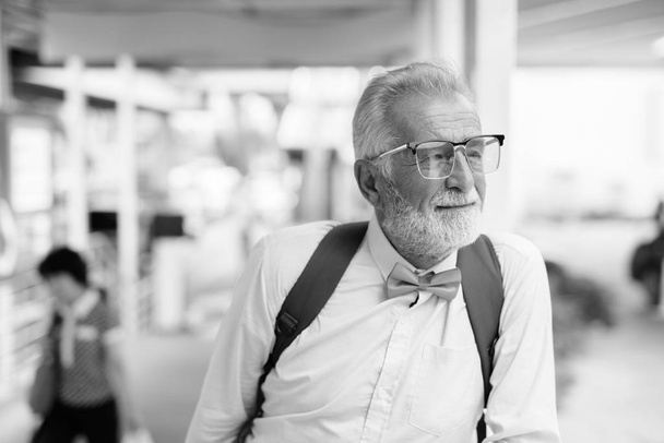 Красивый бородатый старший турист исследует город в черно-белом
 - Фото, изображение
