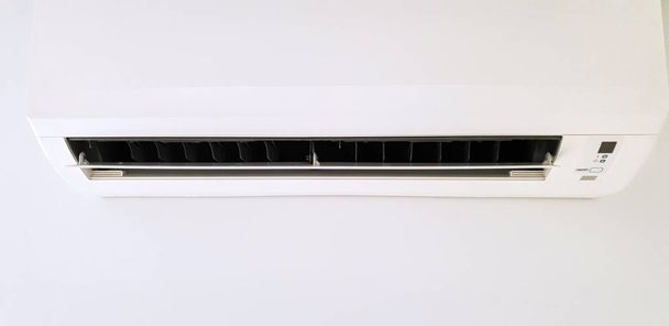 Moderna unidad de aire acondicionado en una pared blanca dentro de la sala de estar
 - Foto, imagen