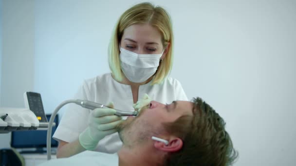 Zahnarzt putzt Zähne mit elektrischen Geräten - Filmmaterial, Video