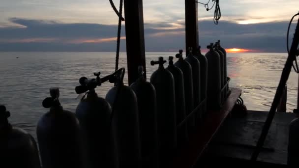 Fila de tanques de oxígeno y equipo de buceo colocado en barco moderno en el océano ondulante cerca de Koh Tao resort, Tailandia. Concepto de deportes turísticos de entretenimiento extremo, aventura y nueva experiencia. - Imágenes, Vídeo