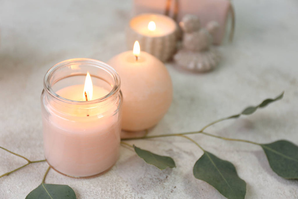 Gloeiende kaarsen met eucalyptus op tafel - Foto, afbeelding