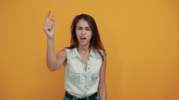 Caucasian young woman in blue denim shirt pointing ar camera, looking angry - Filmagem, Vídeo