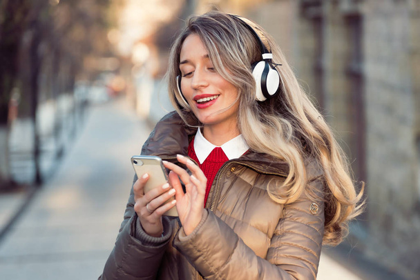 Boldog nő zenét hallgat vezeték nélküli fejhallgatón - Fotó, kép