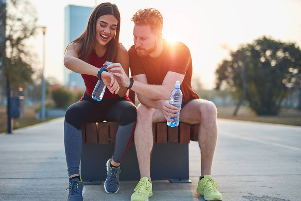 Couple moderne faisant une pause dans un parc urbain pendant le jogging / exe
 - Photo, image