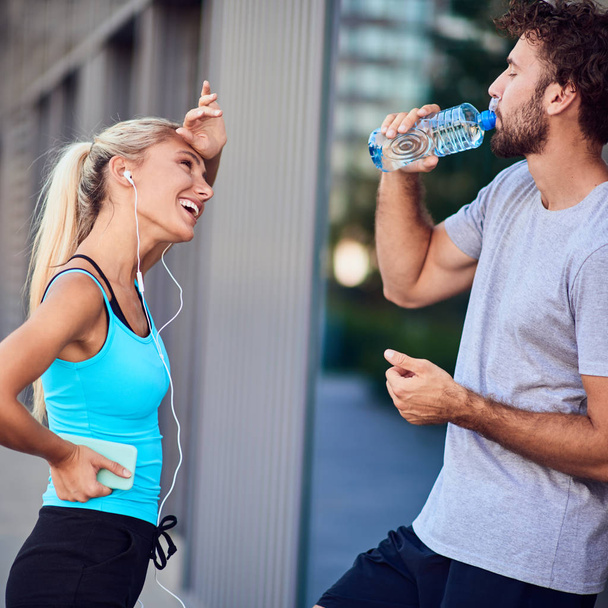 Σύγχρονη νεαρός άνδρας και γυναίκα κάνει παύση μετά από τρέξιμο / άσκηση - Φωτογραφία, εικόνα