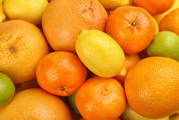Tangerines, sinaasappels, limoenen en citroen als achtergrond, bovenaanzicht - Foto, afbeelding