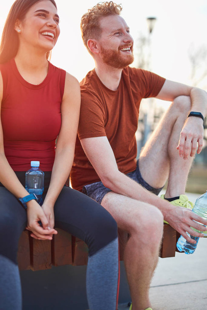 Modern couple making pause in an urban park during jogging / exe - Photo, Image