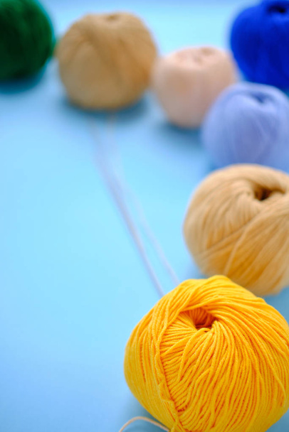 Bright color yarn clews on the blue background. Concept of amigurumi toy making, handicraft, knitting, hobbie - 写真・画像