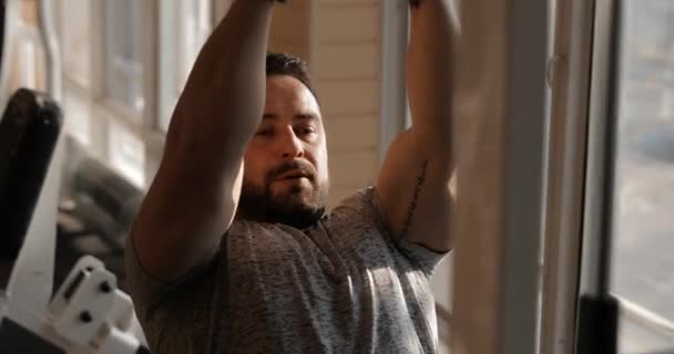 Mann trainiert im Fitnessstudio und stärkt seine Muskeln des latissimus dorsi - Filmmaterial, Video