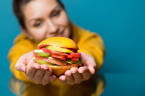 young woman holds out a veggie burger - Фото, изображение
