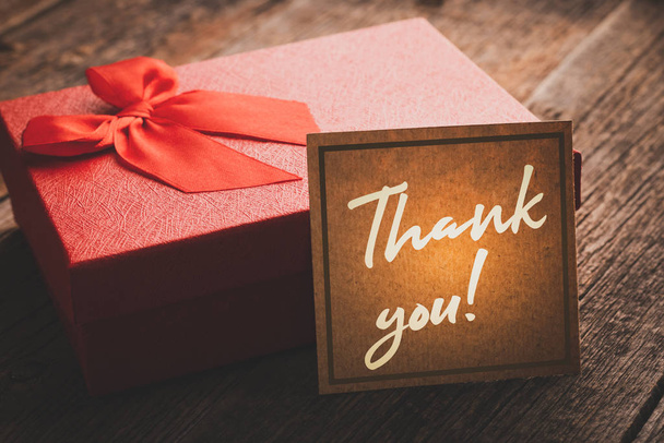 Caja de regalo con una nota de gratitud en una mesa de madera en procesamiento vintage: concepto de expresión de gratitud y agradecimiento
 - Foto, imagen