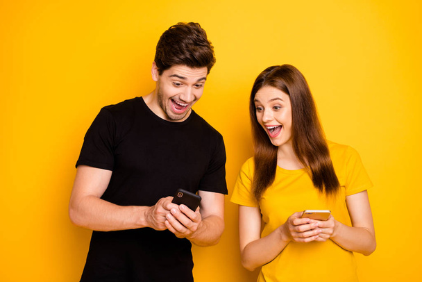 Photo of cheerful excited ecstatic nice overjoyed funky funny couple sharing impressions with each other expressing positive emotions in black yellow t-shirt isolated vivid color background - Фото, изображение