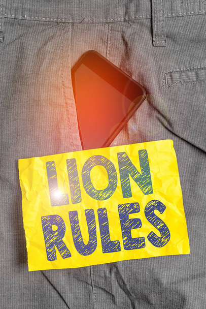 Liścik z "Lion Rules". Biznesowe zdjęcie ukazujące uosobienie siły i męskości Master of own domain Smartphone device inside trousers front pocket note paper. - Zdjęcie, obraz