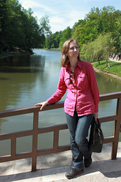 μια γυναίκα στέκεται σε γέφυρα πάνω από τον ποταμό - Φωτογραφία, εικόνα
