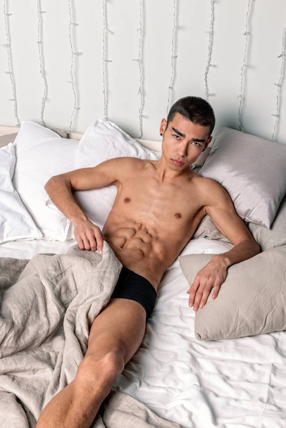 Young handsome man rest in bed. Sexy naked guy is resting - Fotó, kép
