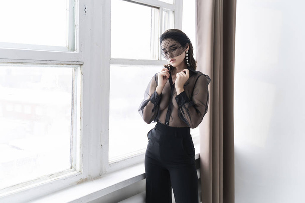 A beautiful Asian girl wearing trousers, a transparent blouse an - 写真・画像