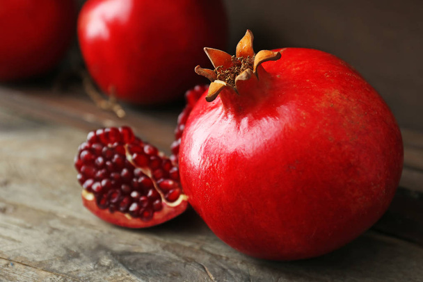 Tasty pomegranate on wooden table - Фото, изображение