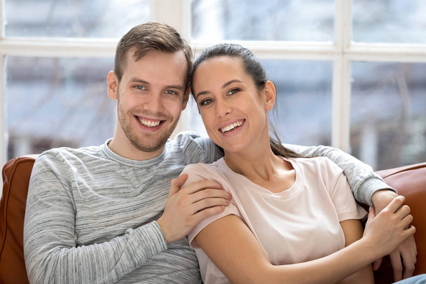 Porträt eines glücklichen Paares, das zu Hause vor der Kamera posiert - Foto, Bild