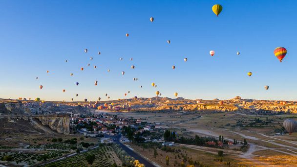 Kapadokya Türkiye 'de kayaların üzerinde uçan sıcak hava balonu - Fotoğraf, Görsel